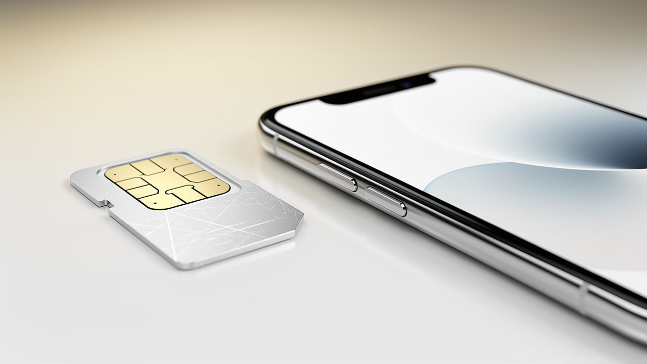 Physical SIM card placed next to a modern eSIM-enabled smartphone
